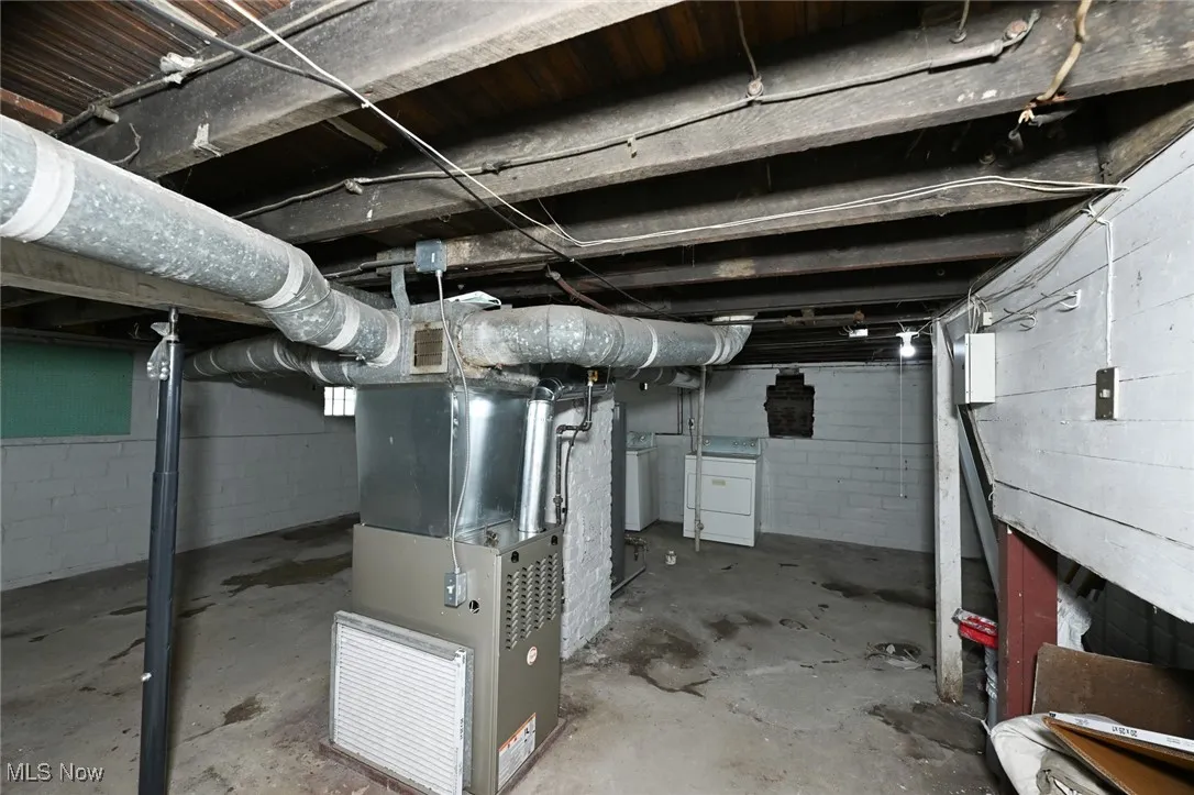 Unfinished below grade area with washer / dryer and heating unit