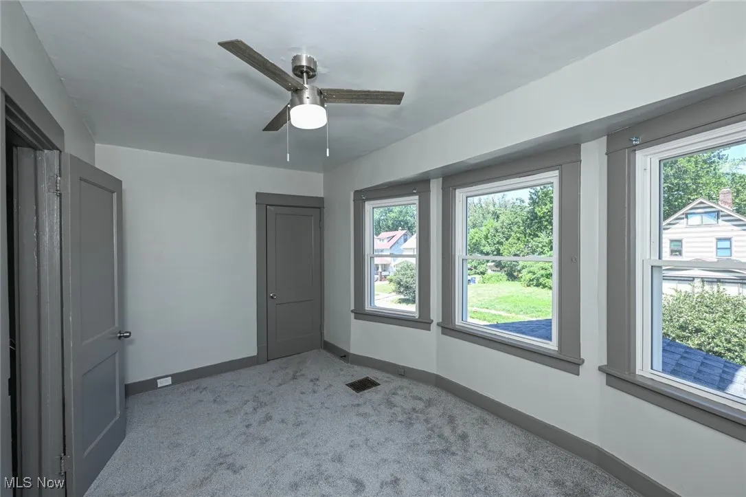 Unfurnished bedroom featuring carpet floors, a closet, and a ceiling fan