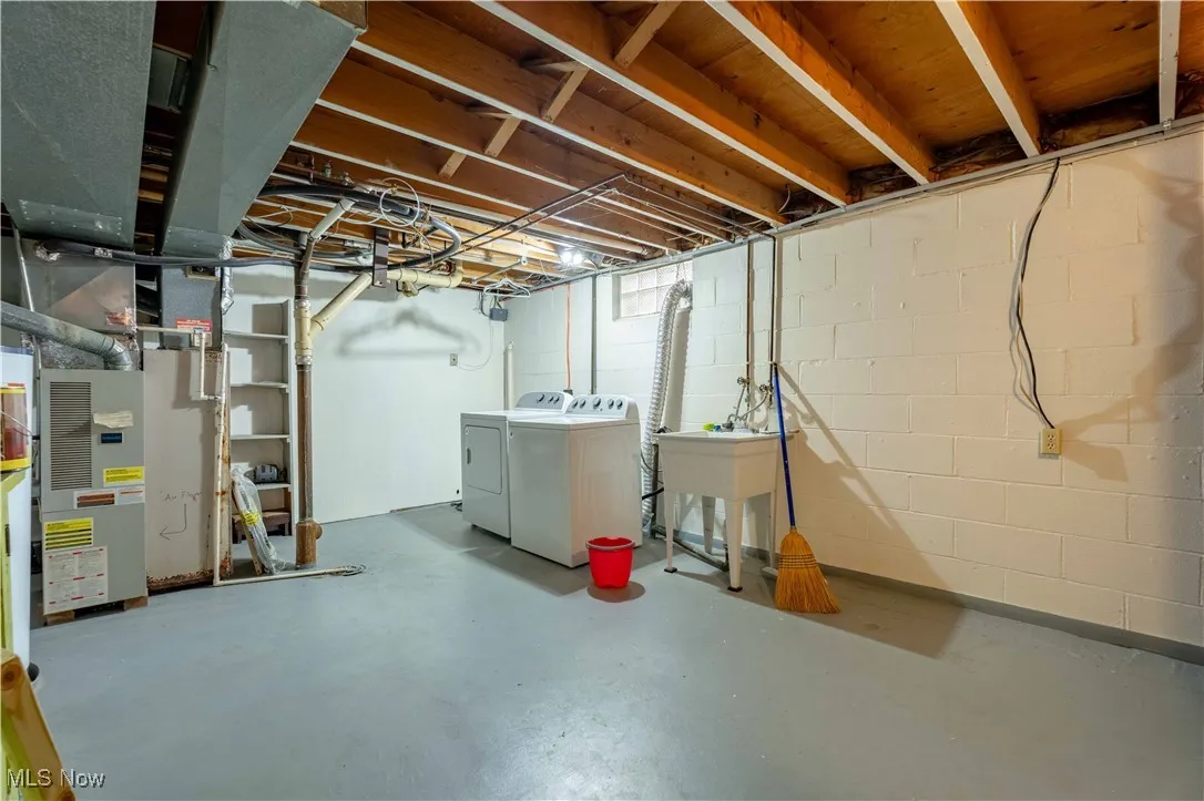 Unfinished basement featuring washing machine and clothes dryer