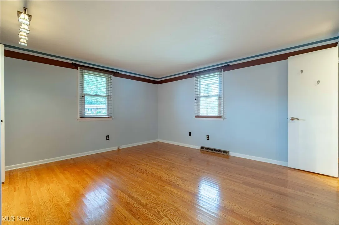 Unfurnished bedroom with multiple windows and light wood finished floors