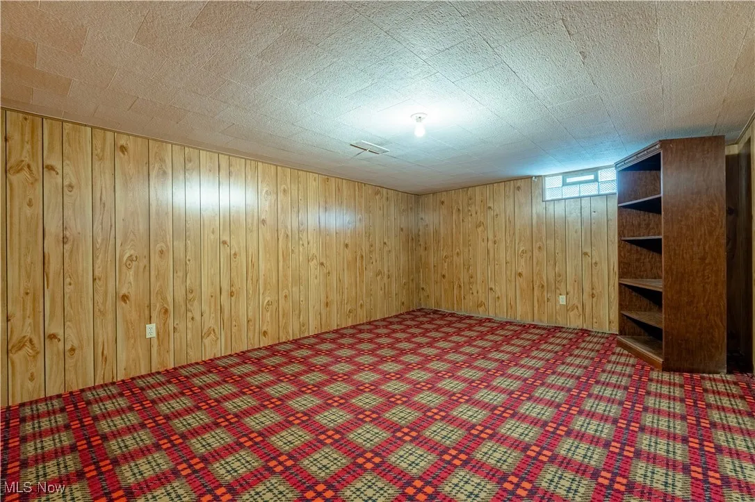 Below grade area with wood walls and carpet floors