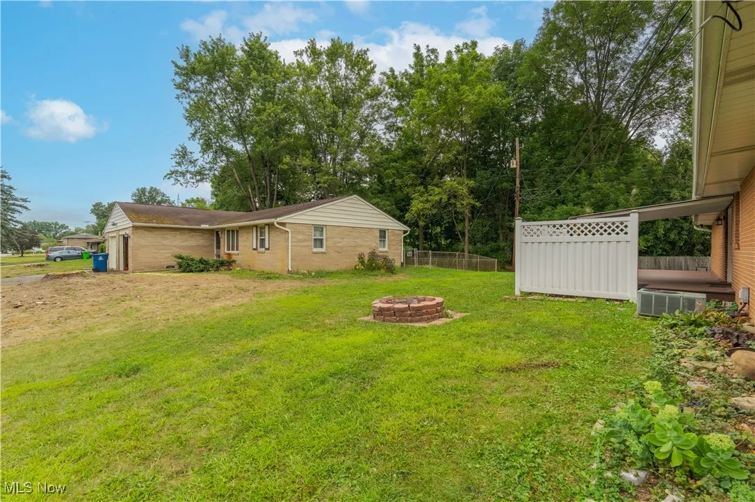 View of yard with a fire pit and a garage