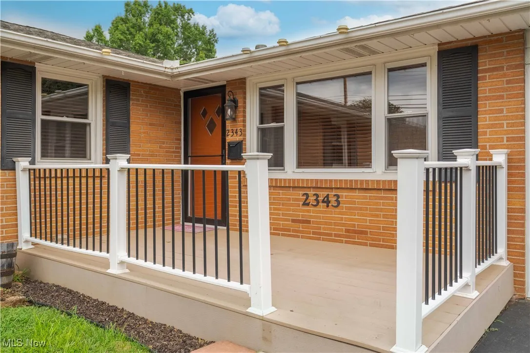 Entrance to property featuring brick siding and a porch