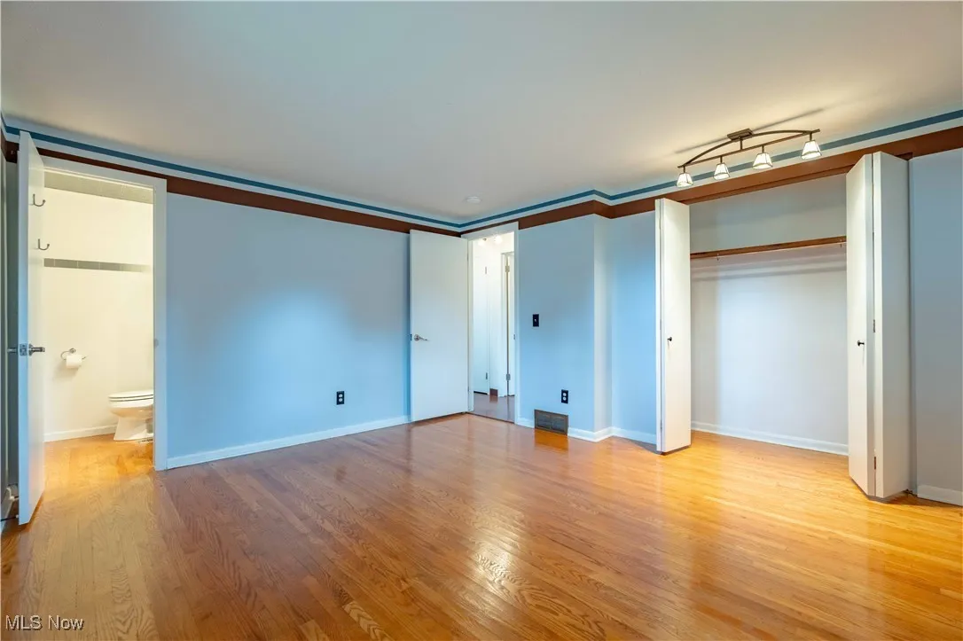 Unfurnished bedroom with light wood-style flooring, a closet, and ornamental molding