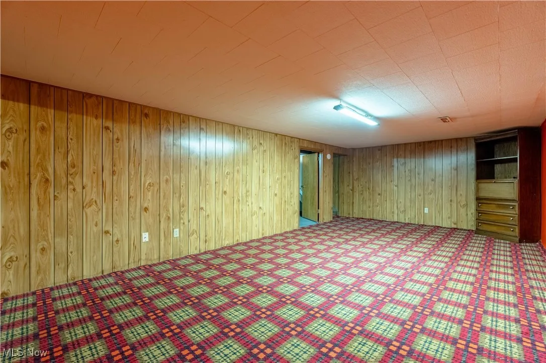 Finished below grade area with wood walls and carpet flooring