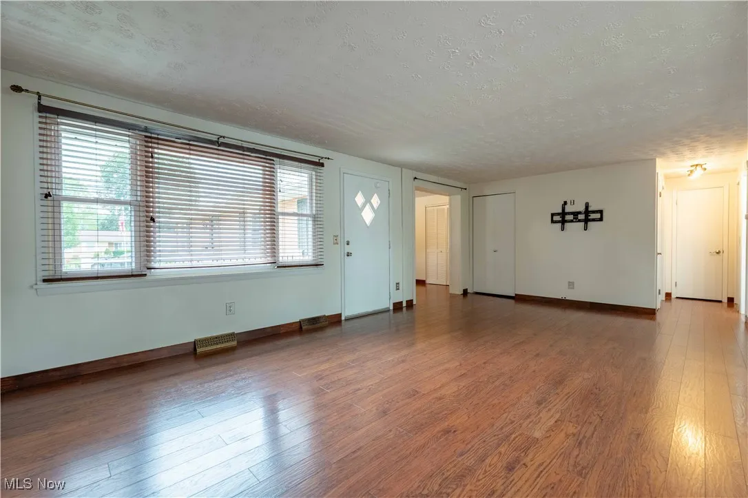Unfurnished living room with a textured ceiling and wood-type flooring