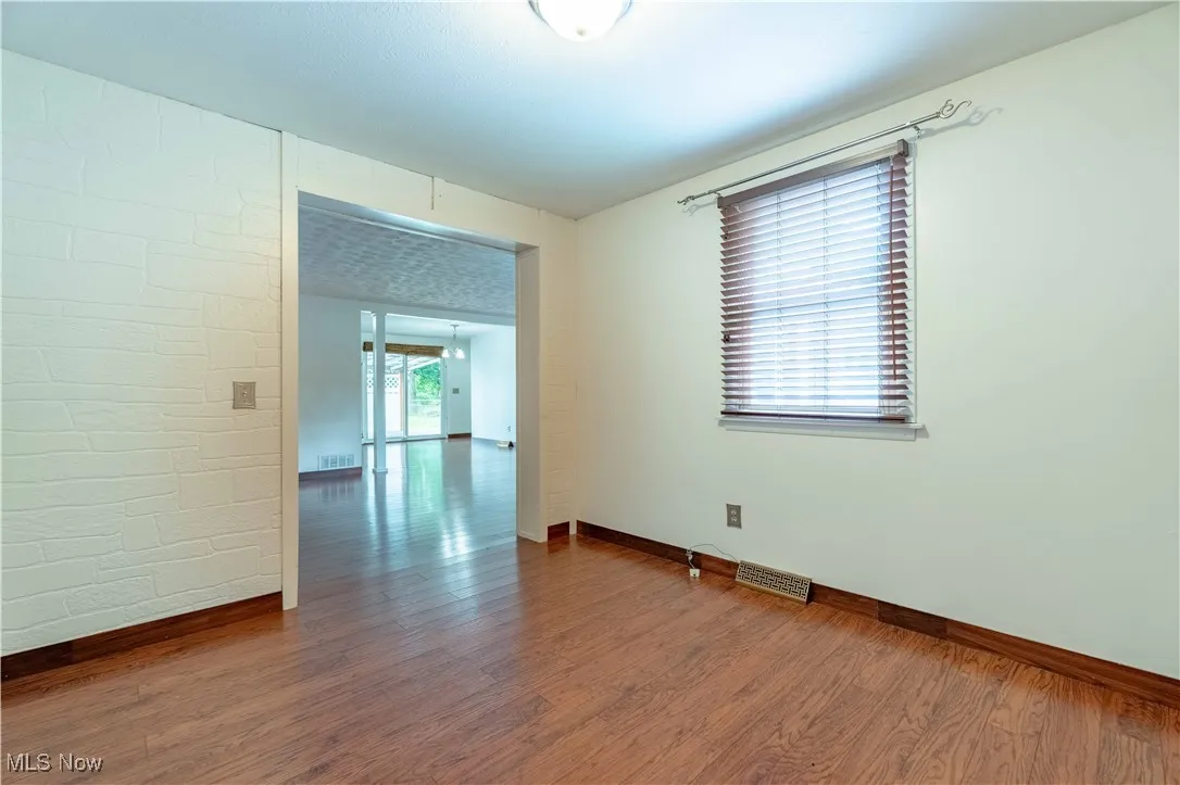 Unfurnished room featuring dark wood-type flooring and baseboards