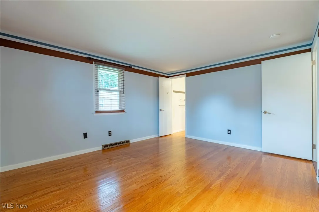 Unfurnished bedroom featuring light wood finished floors and baseboards