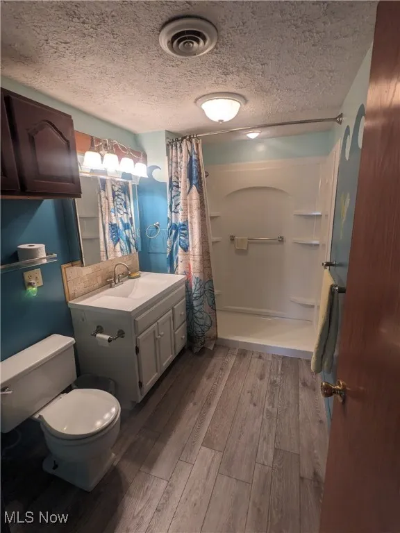 Bathroom with vinyl plank flooring and walk-in shower.