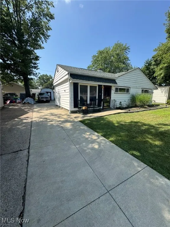 Ranch-style house with a front lawn, an outbuilding, and a porch