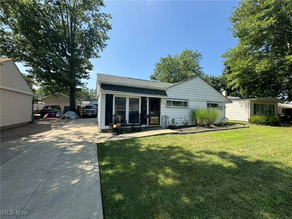 Back of property with a yard and roof with shingles