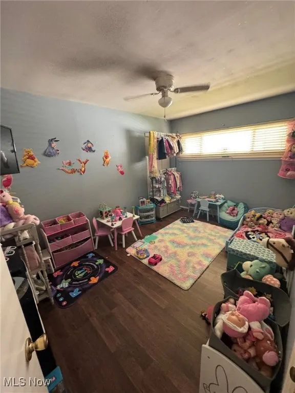 Rec room featuring dark wood finished floors, a textured ceiling, and ceiling fan