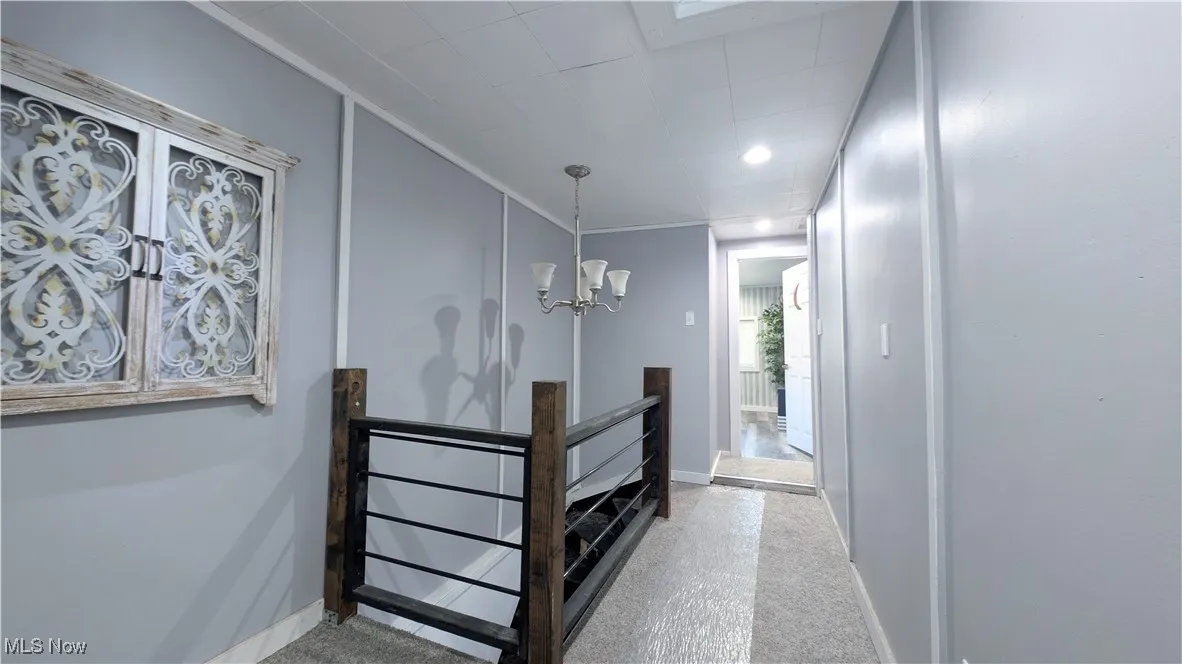 Hallway with a chandelier and an upstairs landing