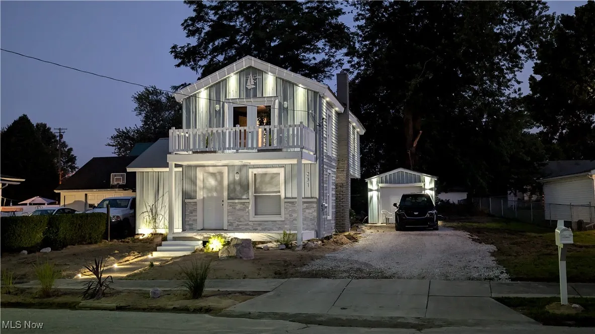 View of front facade with a balcony, and accent lighting