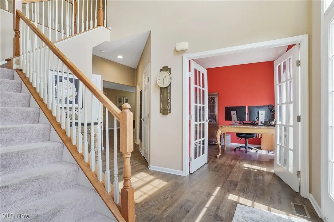 Staircase featuring french doors and wood finished floors