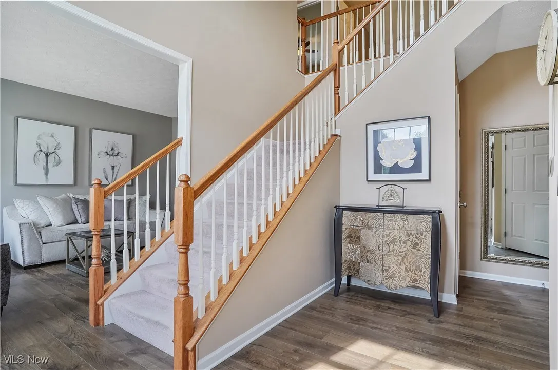 Stairway with wood finished floors and baseboards