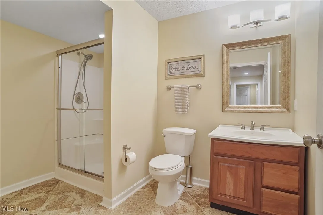 Bathroom featuring a shower stall and vanity