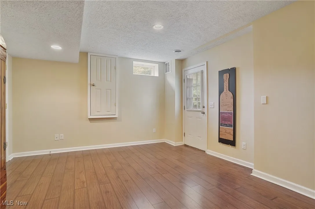 Unfurnished room with a textured ceiling, wood finished floors, and recessed lighting
