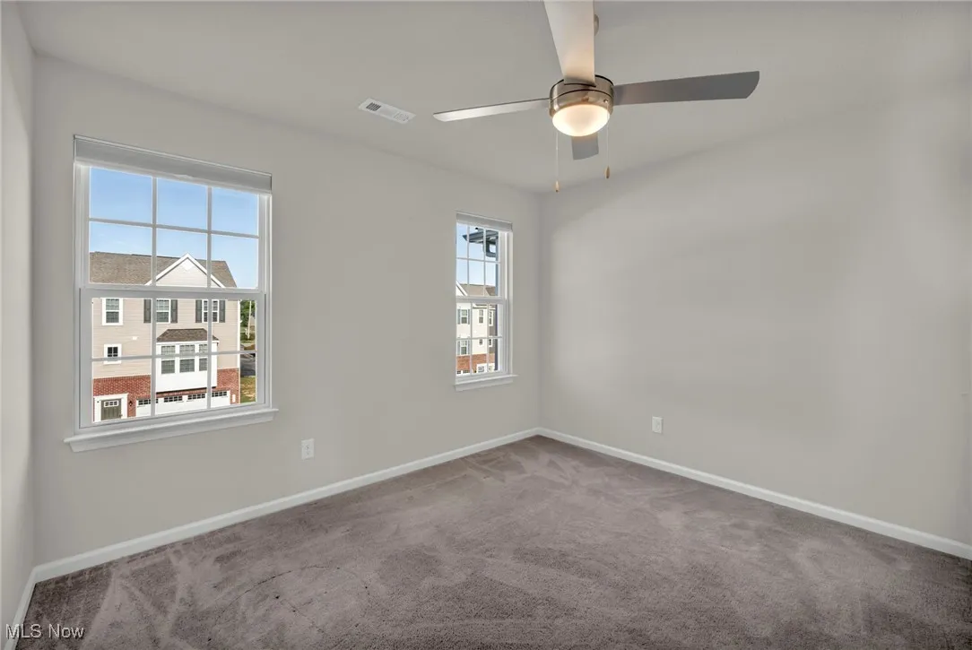 Empty room featuring carpet and a ceiling fan