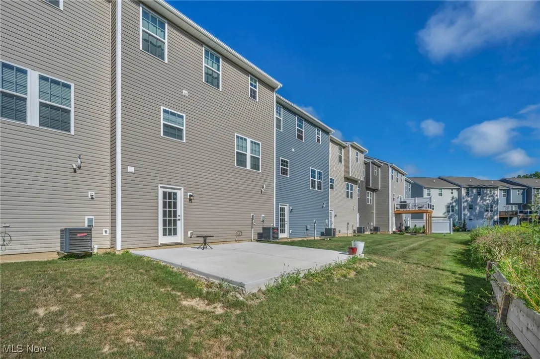 Rear view of house featuring a patio area, a lawn, and a residential view