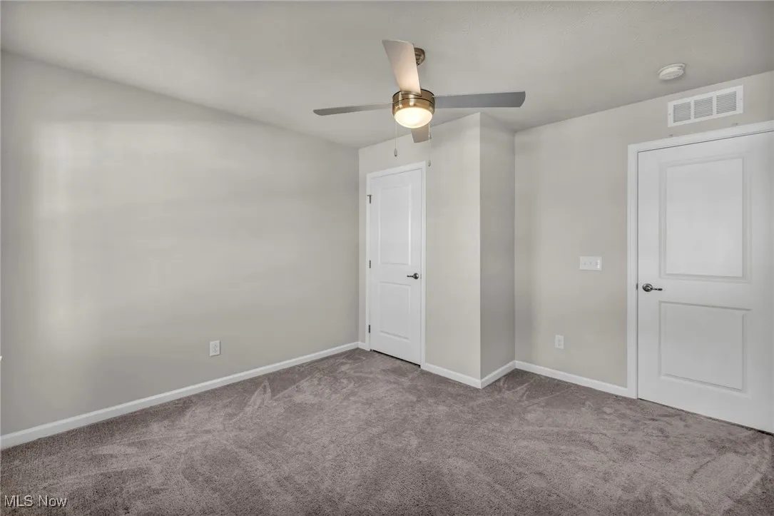 Unfurnished bedroom featuring carpet floors and ceiling fan
