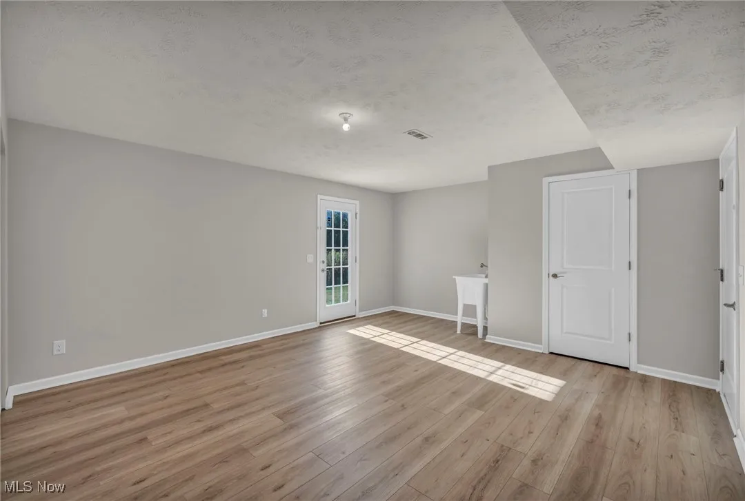Empty room with a textured ceiling and light wood-style​​‌​​​​‌​​‌‌​‌‌​​​‌‌​‌​‌​‌​​​‌​​ flooring