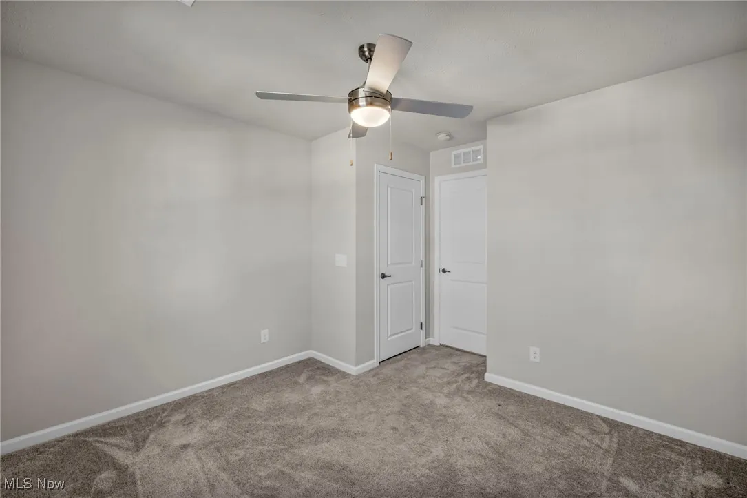 Spare room with carpet flooring and ceiling fan
