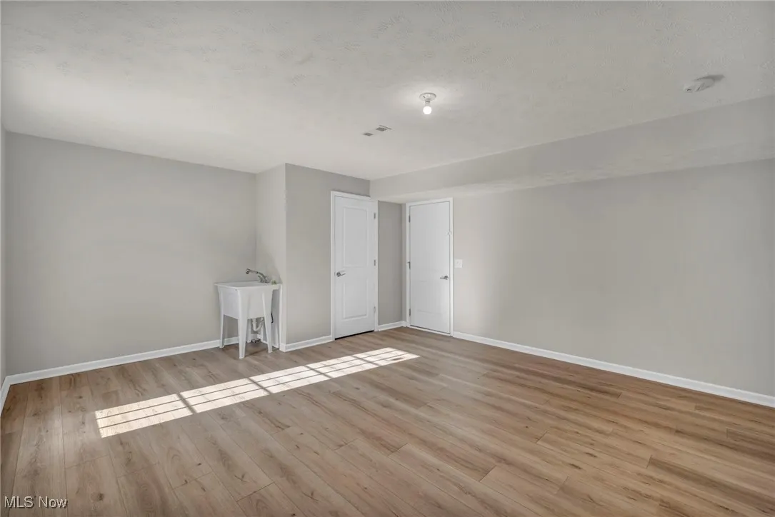Unfurnished room featuring light wood-style floors and a textured ceiling