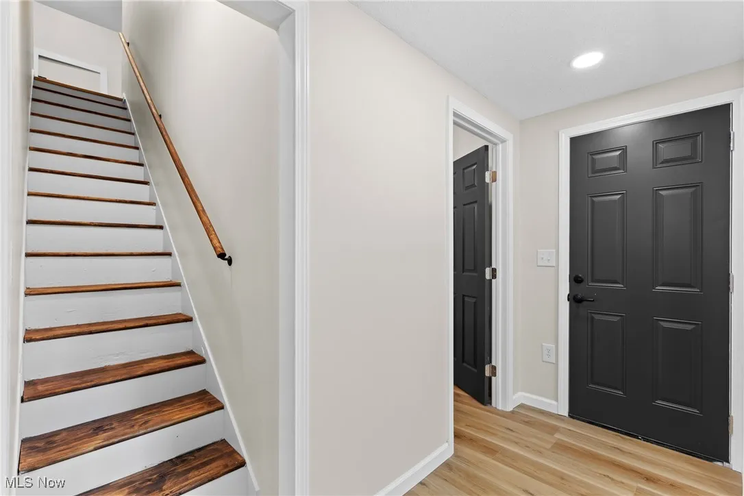 Staircase featuring wood finished floors and recessed lighting