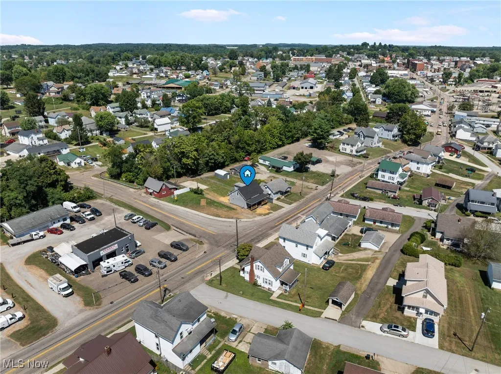Aerial view of property and surrounding area featuring nearby suburban area