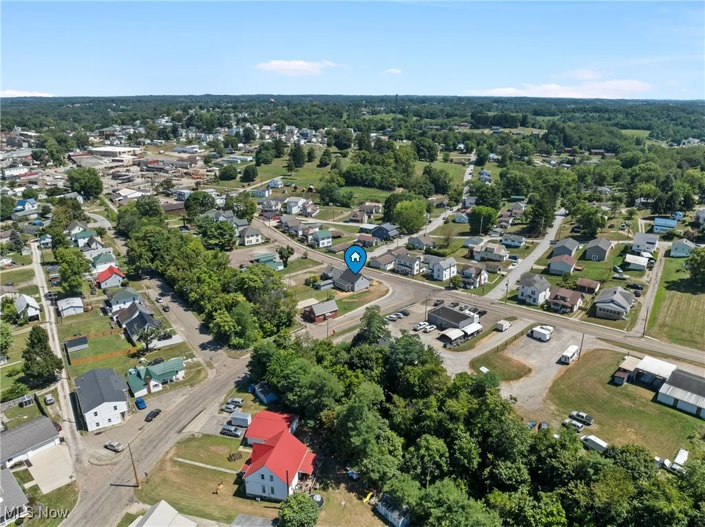 Aerial view of property and surrounding area featuring nearby suburban area