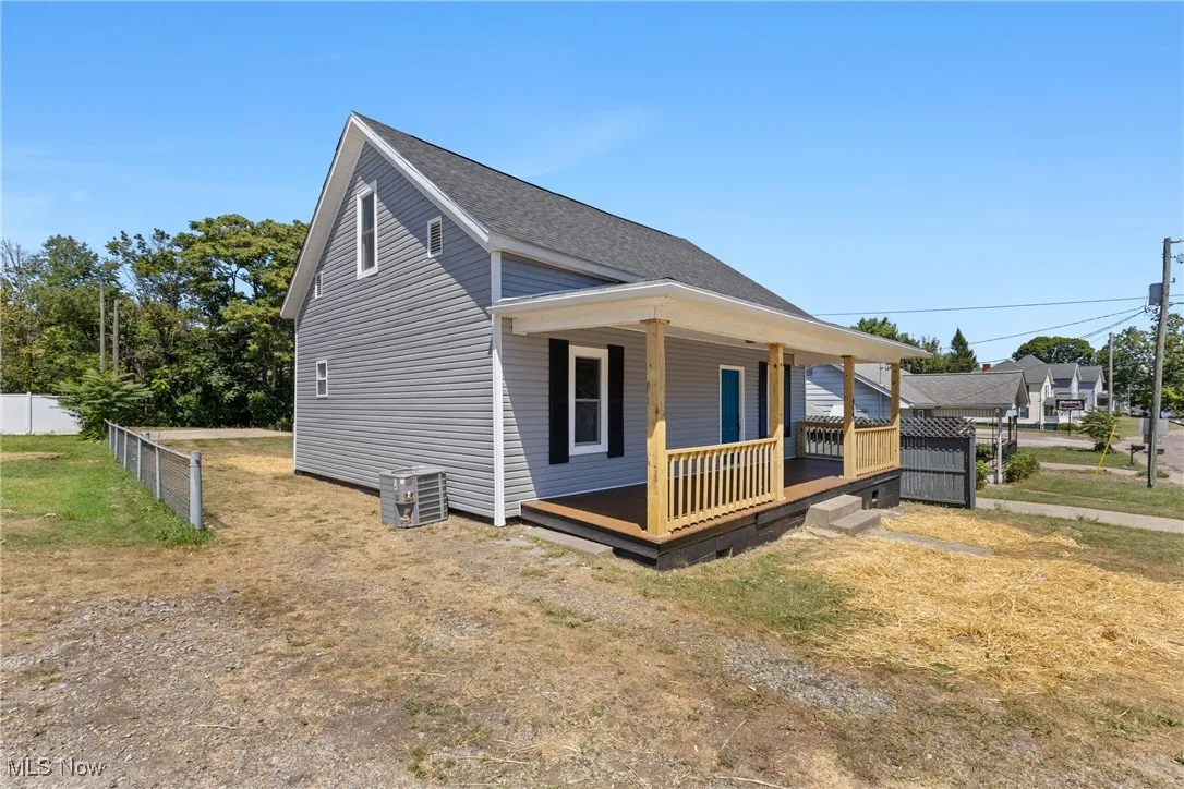 View of front of home with covered porch and a shingled roof