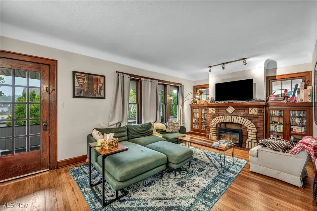 Living area with wood finished floors, a fireplace, and plenty of natural light