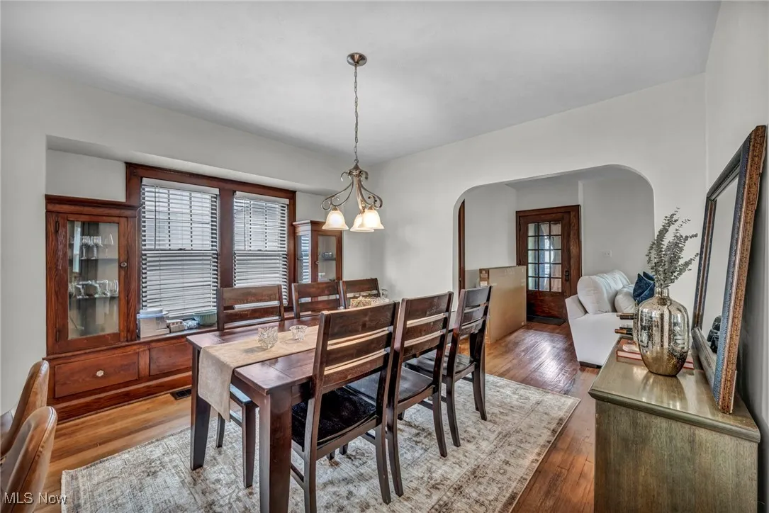 Dining area with hardwood / wood-style floors and arched walkways
