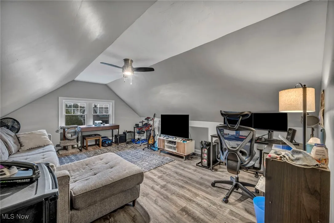 Office with vaulted ceiling, wood finished floors, and a ceiling fan