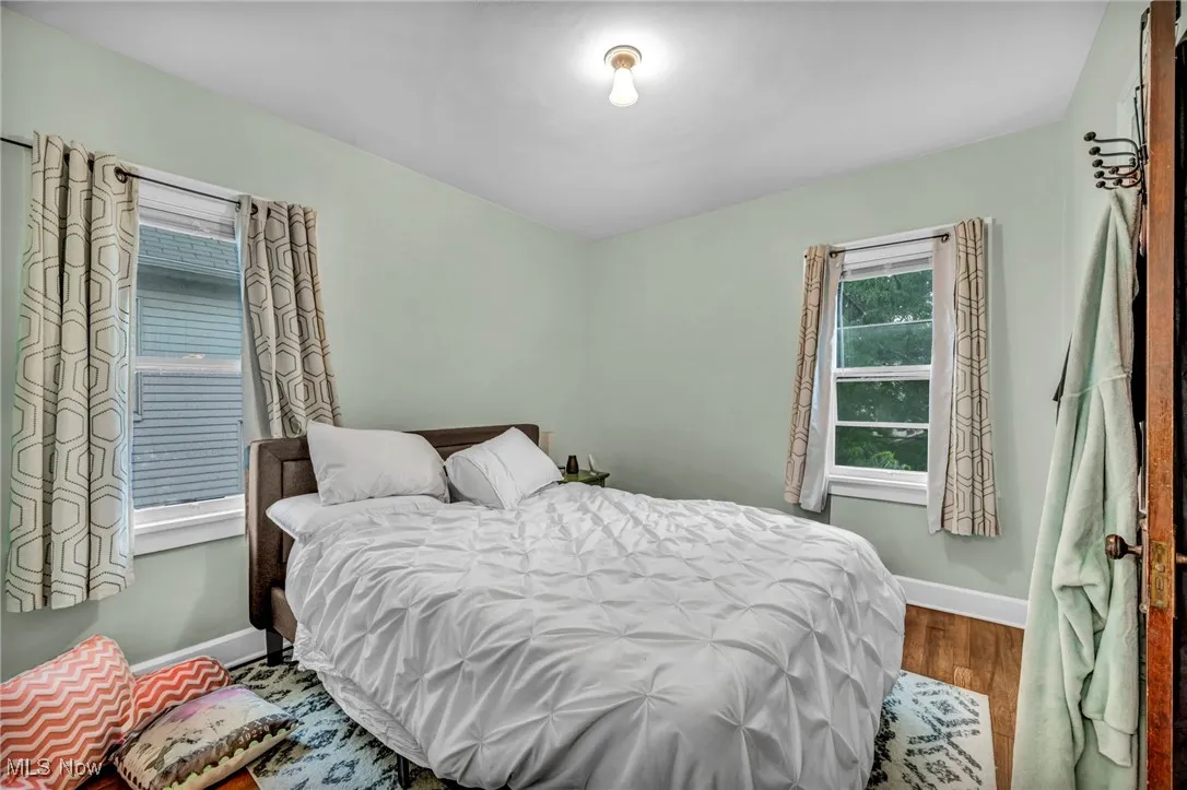 Bedroom with wood finished floors and baseboards