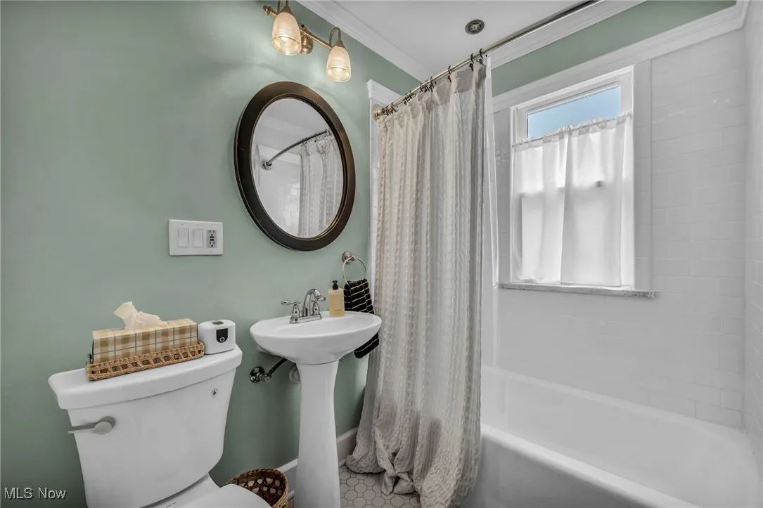 Bathroom with shower / bath combo and crown molding