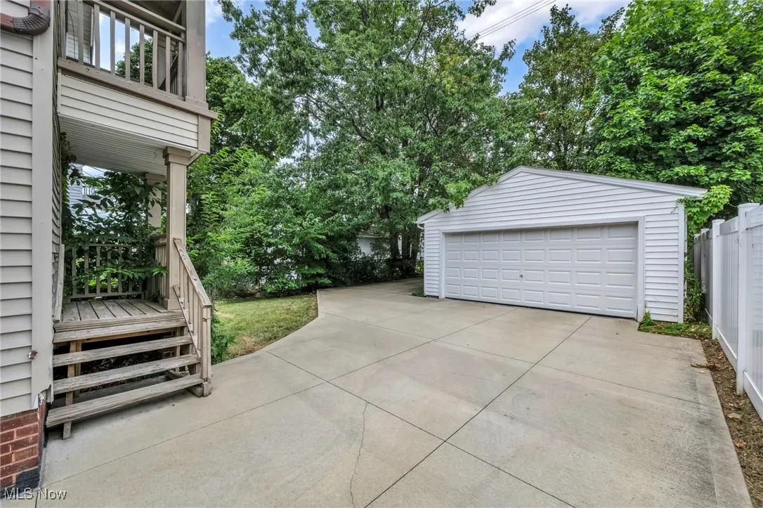 Detached garage featuring view of wooded area