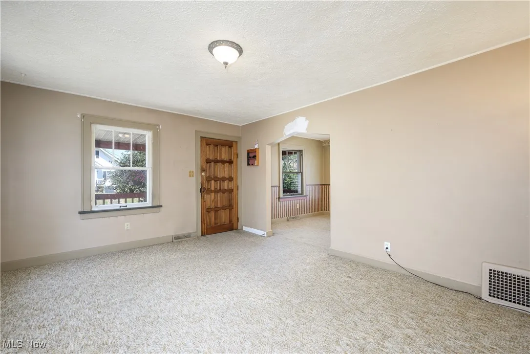 Living room featuring a textured ceiling, carpet floors