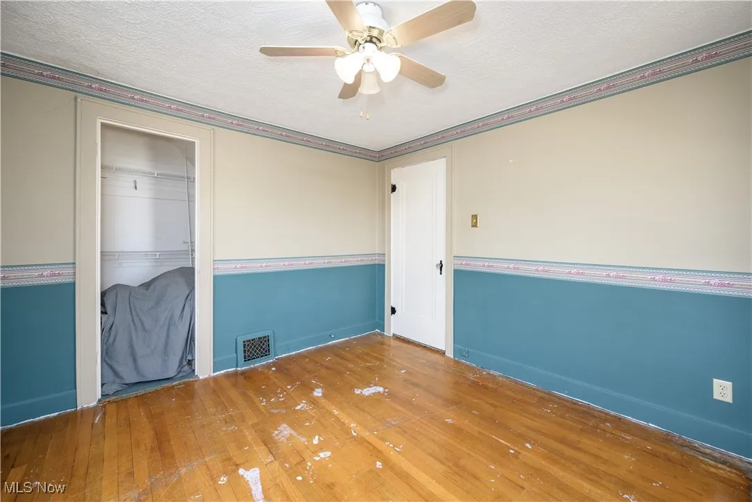 Bedroom featuring wood flooring, a ceiling fan, and a textured ceiling