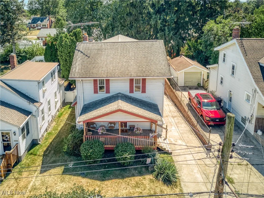 View of front of house featuring a shingled roof, driveway