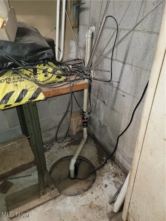 Basement view of concrete floors and drainage system sump pump