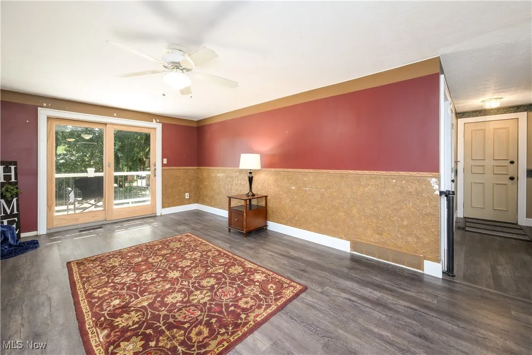 Family room withwaterproof luxury vinyl floors, a stone fireplace, and ceiling fan