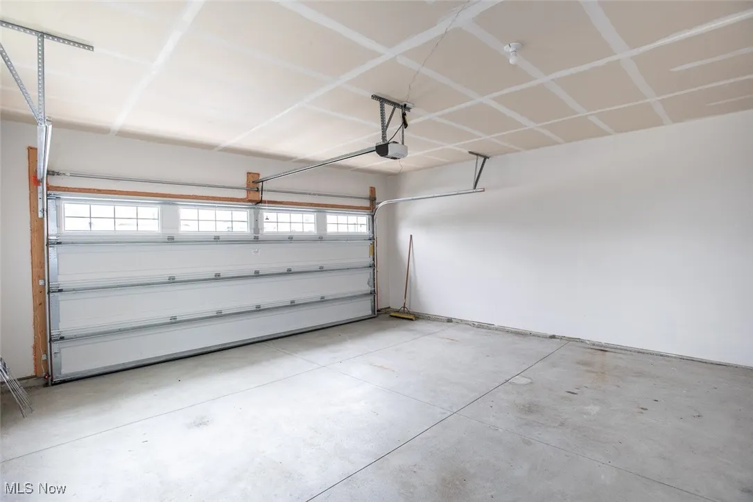 Spacious 2 car garage with storage nook in the back of the garage.