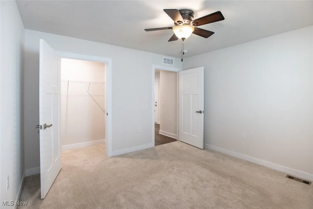 Bedroom 2 with large walk in closet and a ceiling fan.