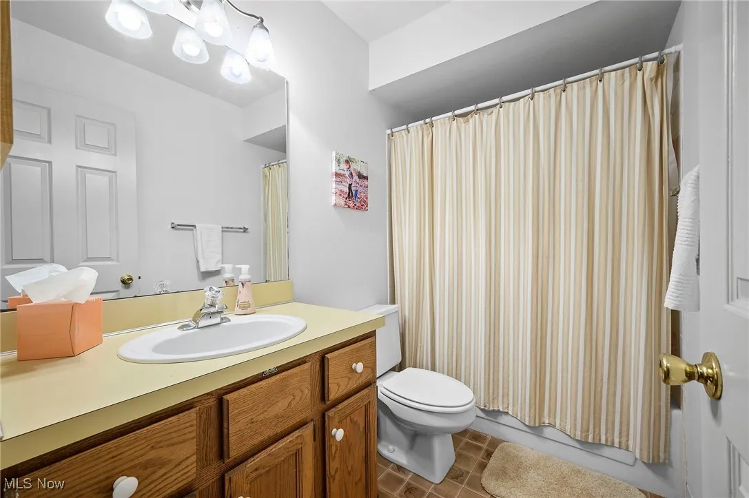 Full bathroom with vanity, tile patterned floors, and shower / bath combo