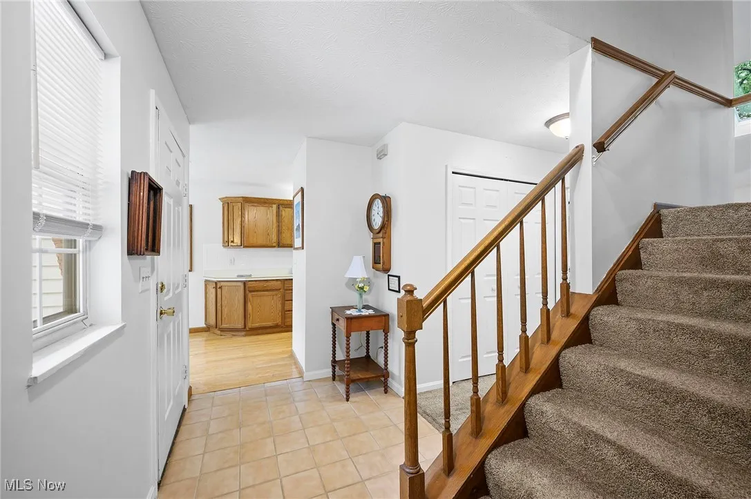 Stairway with plenty of natural light and tile patterned flooring