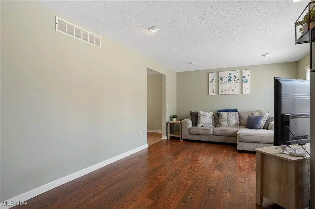Living room with dark wood-type flooring and a textured ceiling
