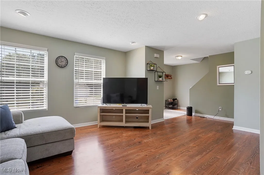 Living area featuring wood finished floors and a textured ceiling