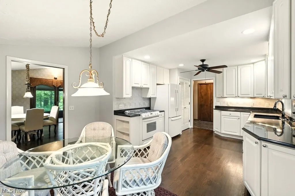 Kitchen featuring dark countertops, white cabinets, dark wood-style floors, recessed lighting, and lofted ceiling